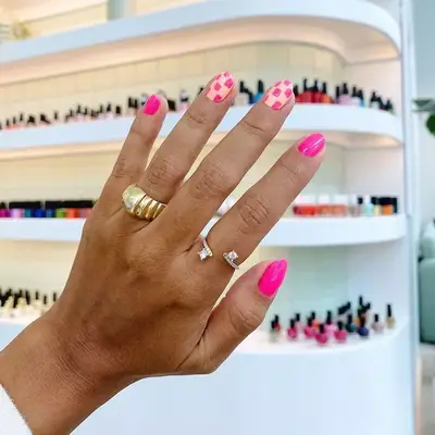 Pink manicure with checkerboard accent nails