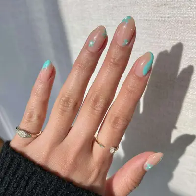 Nude nails with blue swirling blobs and flowers