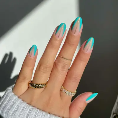 Tiffany-blue nails with a nude colored triangle through the middle and a gold line.