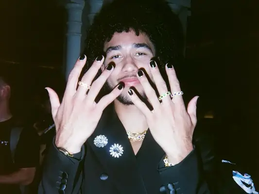 athlete jared mccain showing off a solid black manicure