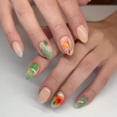 Close up of nude nails with palm leaf, birds or paradise, and hibiscus nail art.