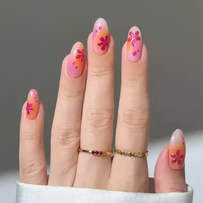 Close up of orange and pink airbrush art nails with pink chrome hibiscus art.