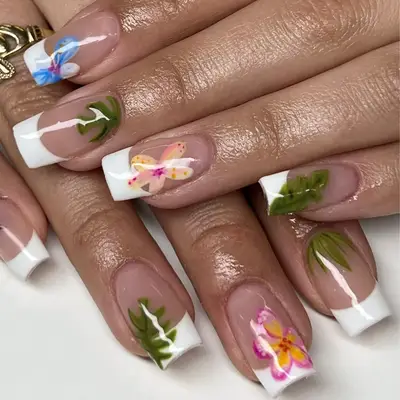 White French tip nails with pink hibiscus flower and palm leaf designs.