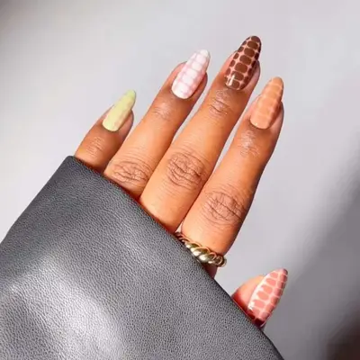 croc print nails with different colors on each finger: green on cream, white on pink, brown on nude, orange on nude, and pink on white.