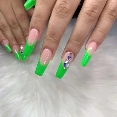 neon green french tip coffin nails with gems on ring finger