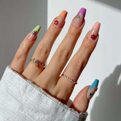 light green, orange, pink, blue, and purple french coffin nails with rhinestone flowers