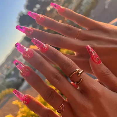 Hot pink coffin nails with golden stickers.
