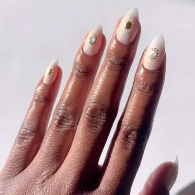 White pearlescent nails with center gemstone accents