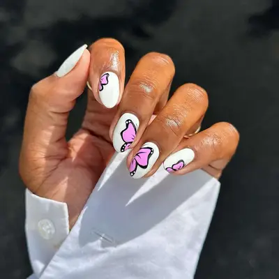 White nails with pink and black butterfly nail art 