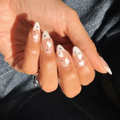 Pearlescent white almond-shaped nails with a diamond ring and band