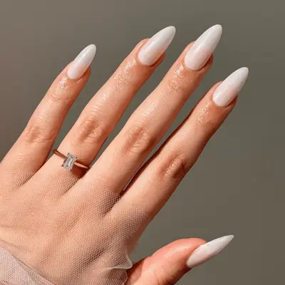 White chrome manicure with rhinestone accents