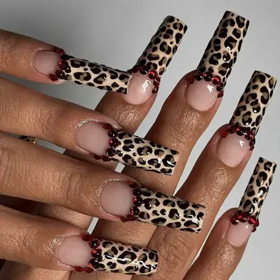 leopard print french manicure with red rhinestones at tips