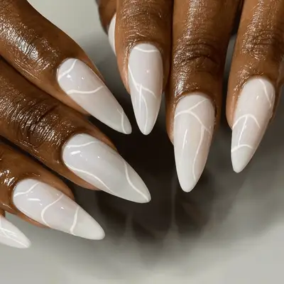 Almond-shape milky white nails with white nail art