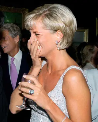 Princess Diana wearing a white beaded sleeveless dress with a French manicure