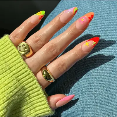playful neon french tips with flower, star, and smiley face designs