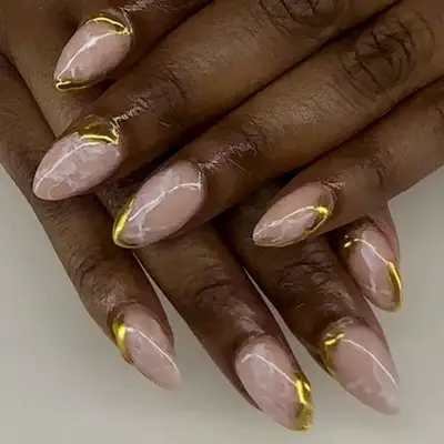 White glossy marble nails with asymmetrical gold tips