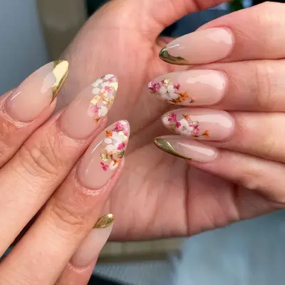 Almond-shaped nails with gold and floral tips 