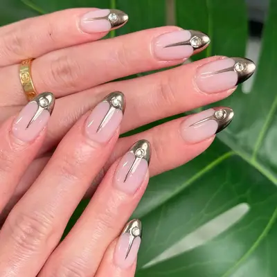 Neutral nails with gold chrome and gem tips