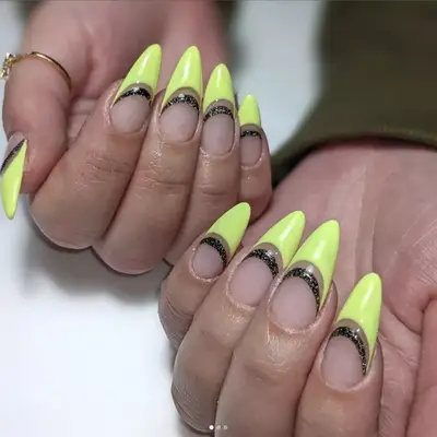 French manicure with yellow tips and a black sparkly arc below.