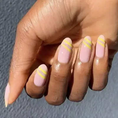 Yellow slashes on a nude based manicure.