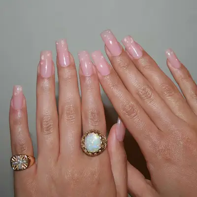 a square nude manicure with builder gel dewdrops