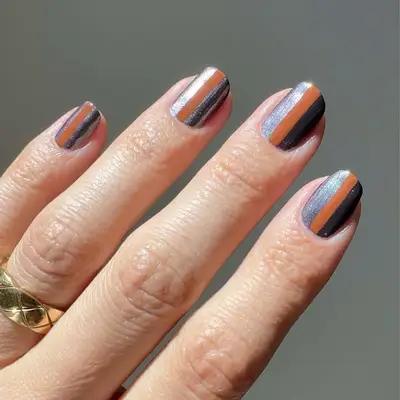 a silver, brown, and gunmetal striped manicure