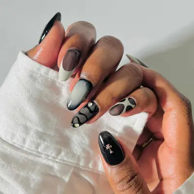 a mismatched manicure in a brown, greige, black, and white color scheme