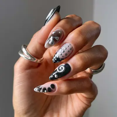 a mismatched black, white, and silver manicure