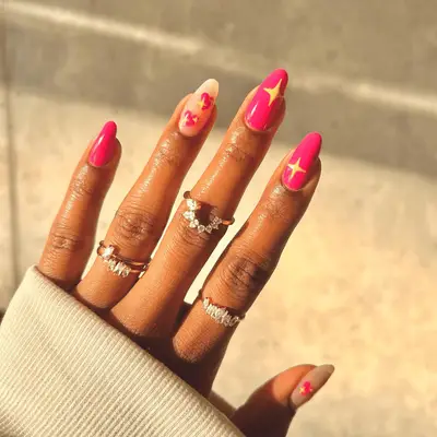 Bright pink manicure with yellow star bursts