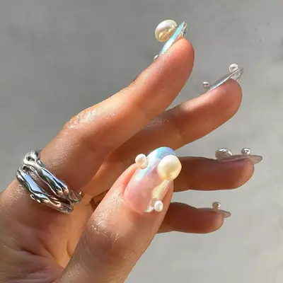 an opalescent manicure topped with pearls