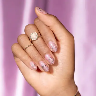 Manicure with pale pink base and sparkly ombre top finish