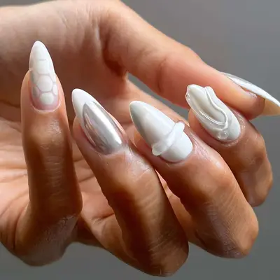 a white mismatched manicure with builder gel and chrome details