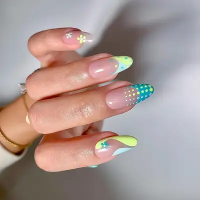 A pastel neon manicure with floral, French tip, and polka dot accents