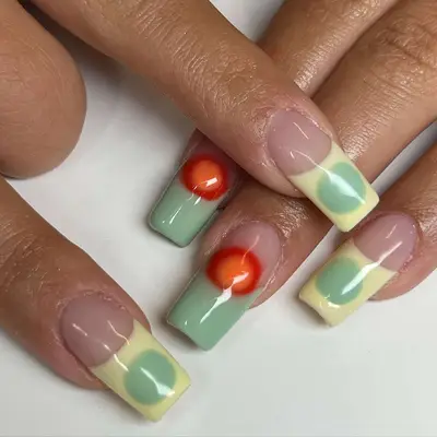Mismatched French manicure with green, yellow, and red tips
