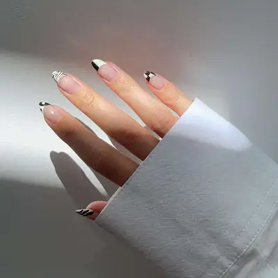Black and white mismatched French tip manicure