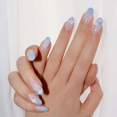 Subtle periwinkle sky manicure with white clouds and bold white stars