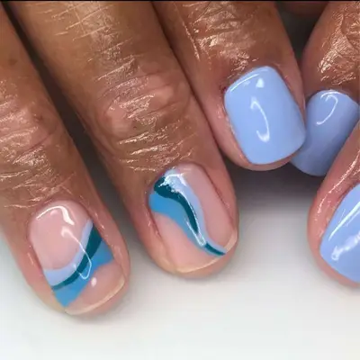 Periwinkle manicure with two wavy design accent nails with neutral base