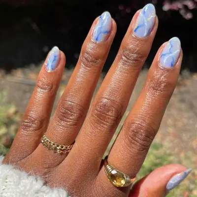 Periwinkle manicure with quartz design in dark blue, pastel blue, and gold