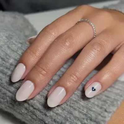 Oatmeal-colored nails with a teeny navy blue heart accent on the pinky