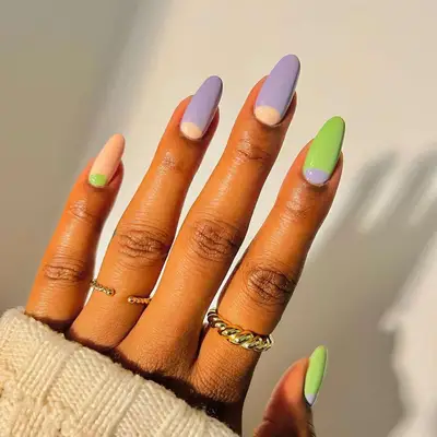 Long oval-shaped nails with peach, lime, and lavender nail art