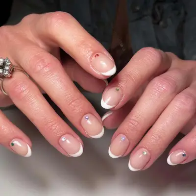 Short French manicure with rainbow gems
