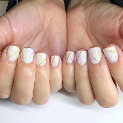 White nails with gold and silver lines