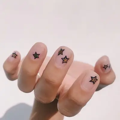 Clear manicure with black and gold star nail designs