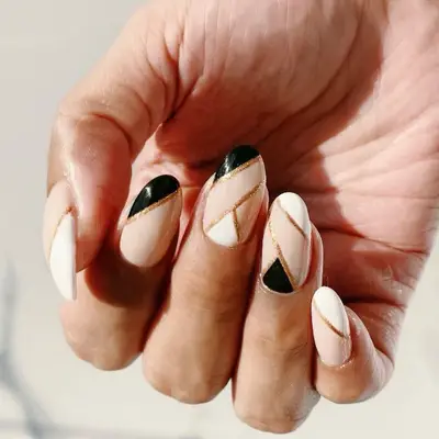 White, nude, black, and gold geometric nail design