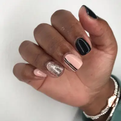 Peach, black, and gold nail design with glitter stripe