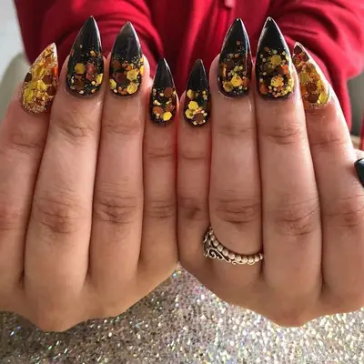 Pointy black nails with gold sequin glitter