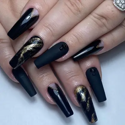 Black gel nail extensions with black and gold accents