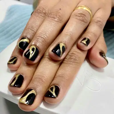 Glossy black nails with abstract gold glitter strokes