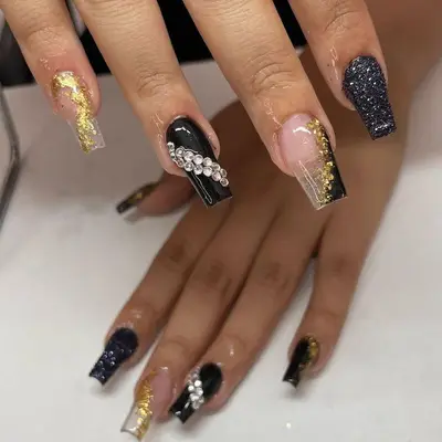 Glittery, bedazzled black and gold nails