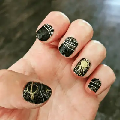 Black and gold nails with small gem details